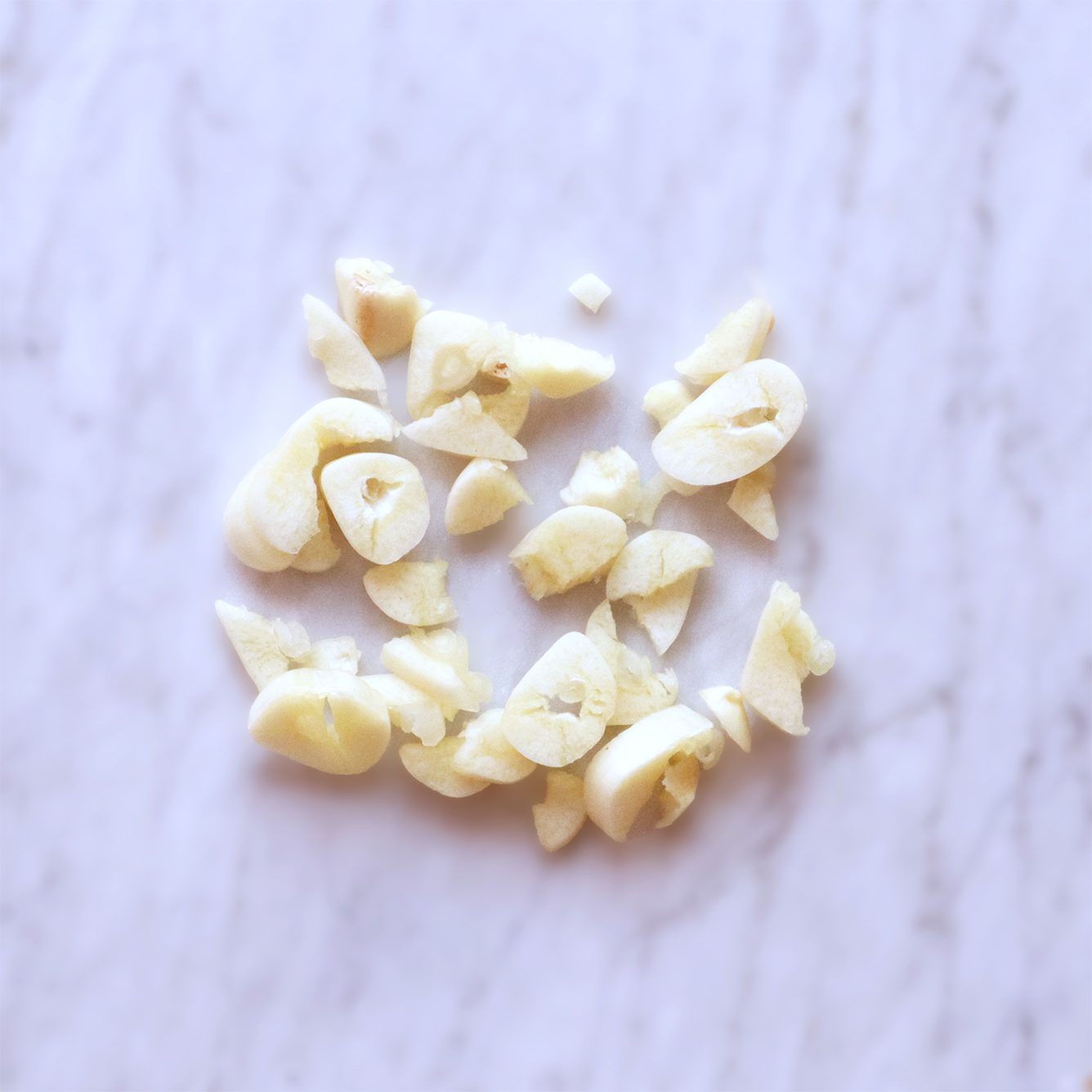 Chopped garlic pieces on a marble surface