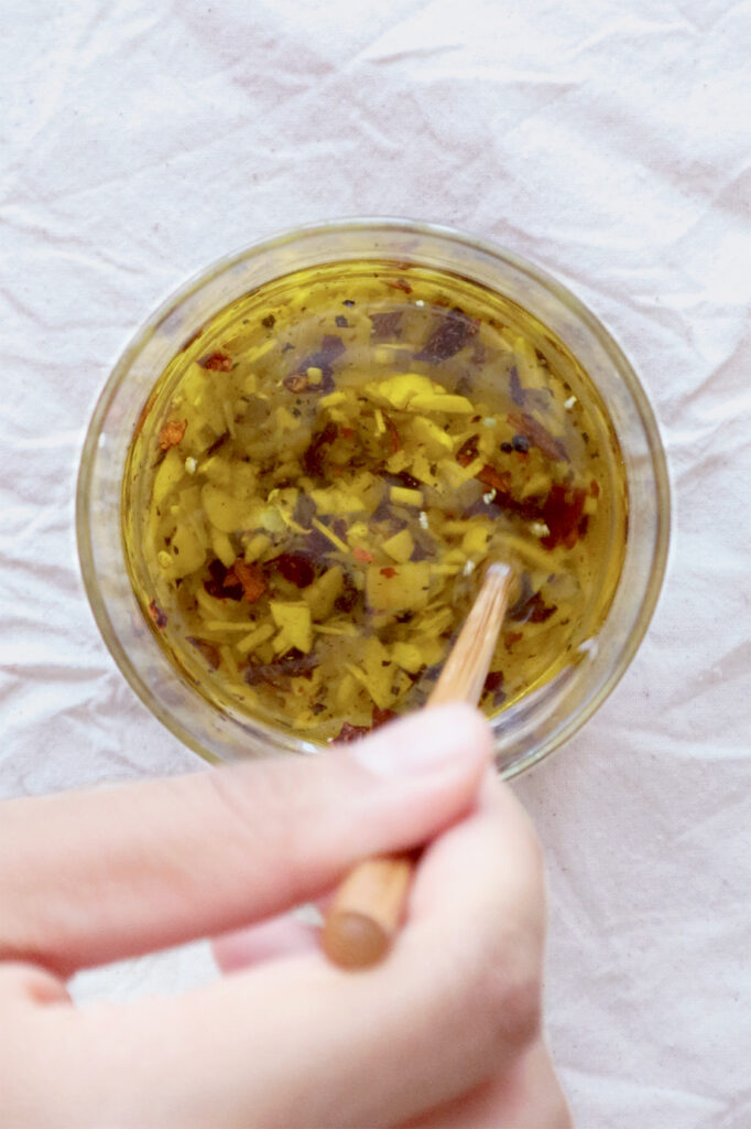 Garlic oil in a glass cup, mixed in motion.