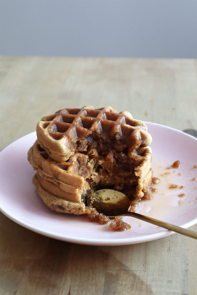 Waffles drenched in maple syrup with a spoon