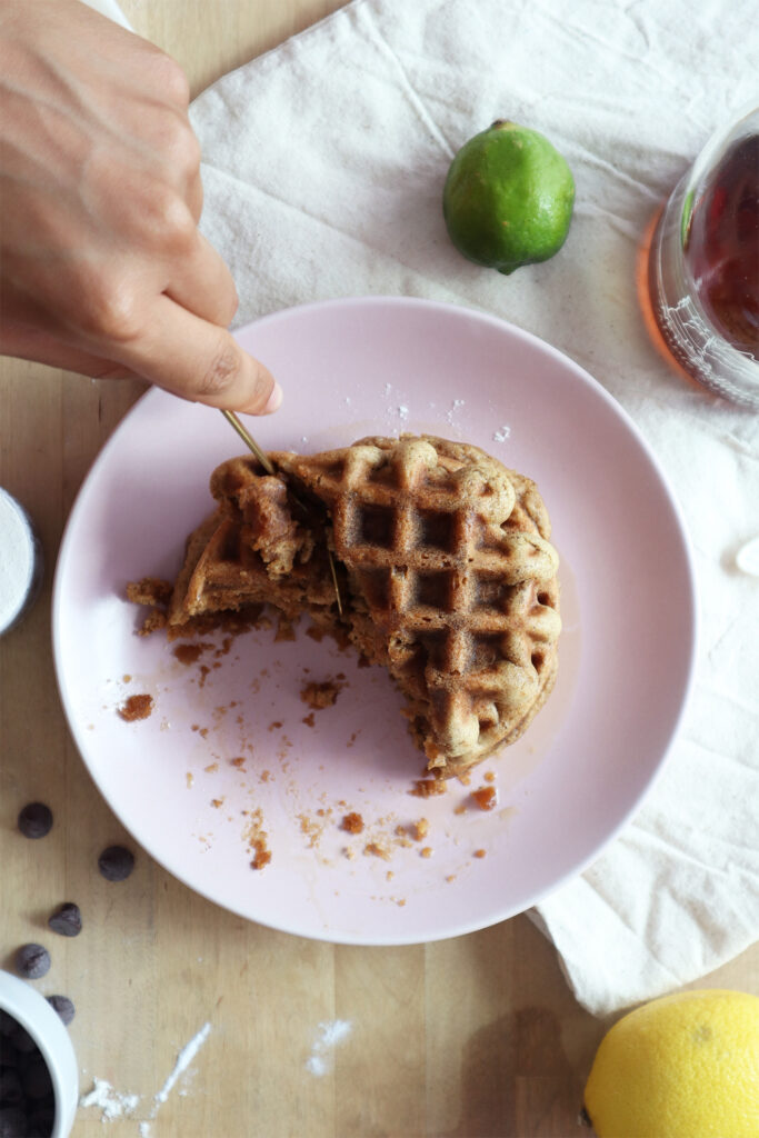 Waffles with a spoon cutting into it. 